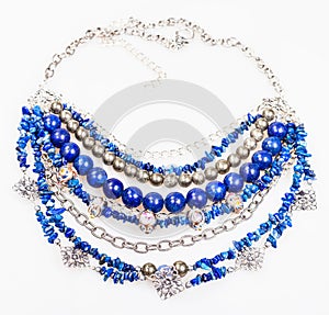 Blue necklace from natural gemstones on white