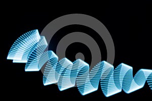 Blue neon curved wave of light as curls or swirl with dotted stripes on black background.