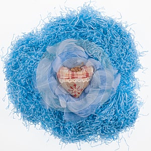 blue nest with Easter eggs with feathers on blue background