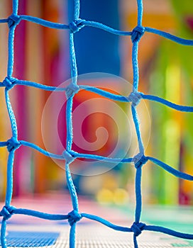 Blue net closeup in children playground. Colorful plastic background