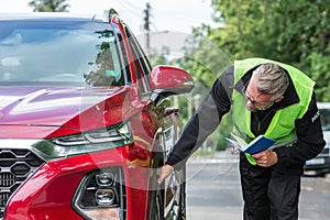 Blue notebook is standing next to the elegant red car that caused the accident