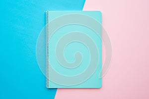 Blue notepad on pink blue background with copy space - Business, education, stationery concept.