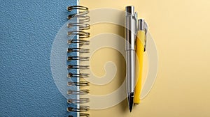 Blue Notepad and Yellow Pen on Yellow Background
