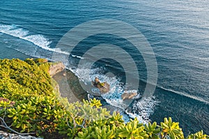 Blue ocean with waves, stones, rocks and cliff in Uluwatu