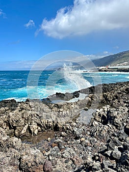 Blue ocean waves and volcanic rocks coast on a sunny day in Los Silos, Tenerife, Canary Islands, Spain