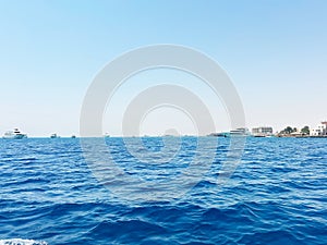 Blue ocean with yachts and distant shoreline