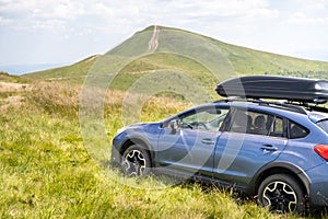 Blue off road car on mountain trail. Traveling by auto, adventure in wildlife, expedition or extreme travel on SUV