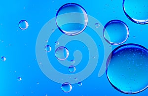 Blue oil drops in water. Bubbles of different sizes