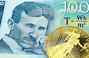 A blue one hundred Serbian dinar bill with a gold coin in macro
