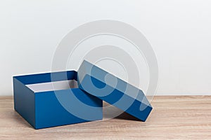 Blue open gift box on wooden table background