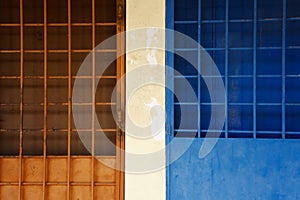 Blue and orange door-grille on the street.