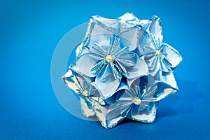 Blue origami flower ball on the blue background