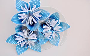 Blue origami flowers made of polka dotted paper.