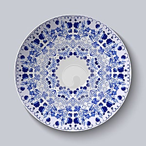 Blue ornament of berries and flowers. Pattern is applied on a ceramic plate.