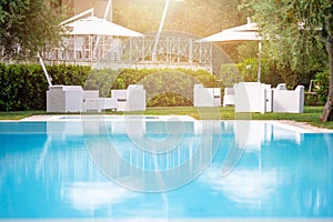 Blue outdoor swimming pool with beach umbrellas