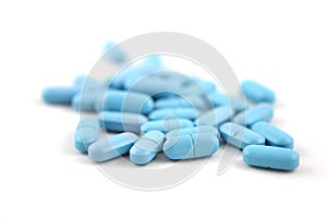 Blue oval pills closeup with sofl natural shadows on white background