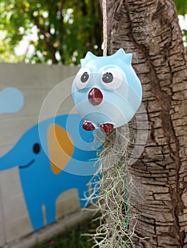 blue owl is hanging under the tree