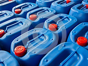 Blue packaging with red caps for packing chemicals is stacked and organized inside warehouse Plastic buckets for keeping quality
