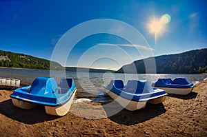 Blue paddle boats on the sandy shore of a lake