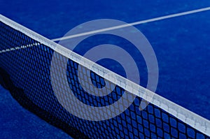 Blue paddle tennis court netting at night