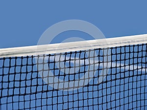 Blue paddle and tennis net and hard court. Professional sport and tennis competition concept