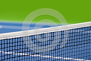 Blue paddle and tennis net and hard court. Professional sport and tennis competition concept