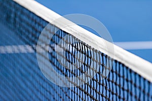 Blue paddle and tennis net and hard court. Professional sport and tennis competition concept