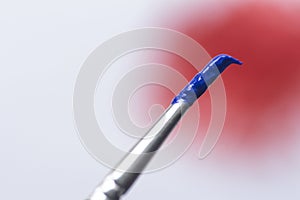 Blue paint brush on white bakcground with red spot