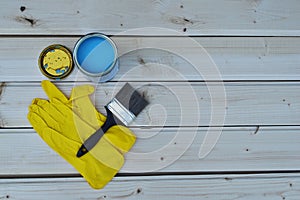 Blue paint in can, brush and yellow gloves