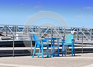 Blue painted chairs and table at a marina