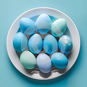 Blue painted eggs arranged on plate, top view Easter composition