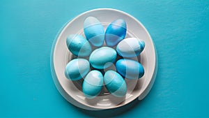 Blue painted eggs arranged on plate, top view Easter composition