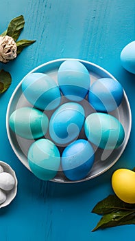 Blue painted eggs arranged on plate, top view Easter composition