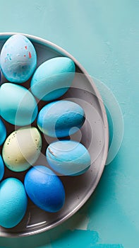 Blue painted eggs arranged on plate, top view Easter composition