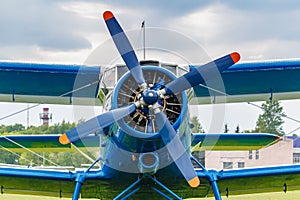 Blue painted legendary soviet aircraft biplane Antonov AN-2 closeup parked on the airfield against cloudy sky