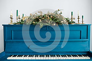 Blue painted old piano decorated with Christmas garland