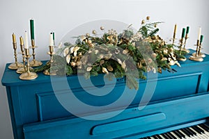 Blue painted old piano decorated with Christmas garland