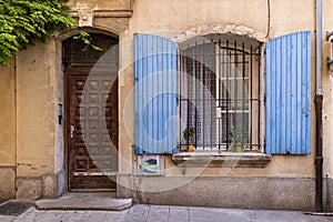 Blue painted shutters on an iron barred window