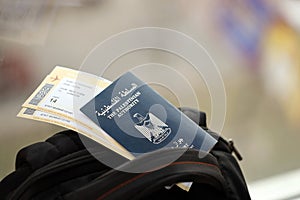 Blue Palestinian Authority passport with airline tickets on touristic backpack close up