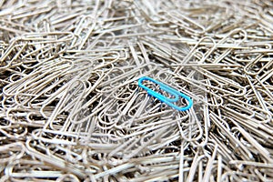 Blue paper clip on paper clips background.