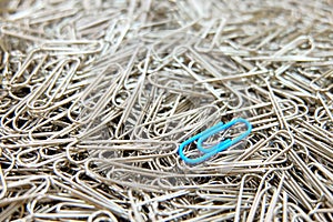 Blue paper clip on paper clips background.