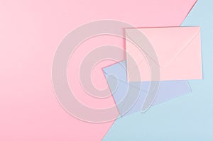 Blue paper envelope composition on pink background