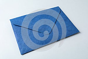 Blue paper envelope on light background, closeup. Mail service