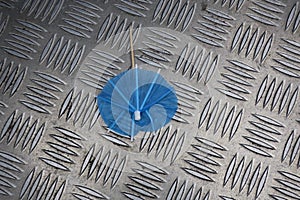 Summertime: paper parasol on aluminium floor