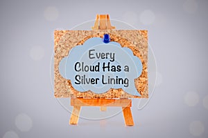 Blue paper speech bubble with phrase Every Cloud Has a Silver Lining on a corkboard