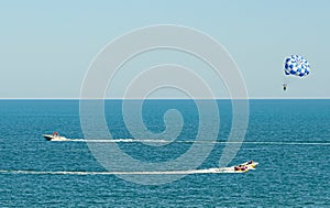 Blue parasail wing pulled by a boat in the sea water, Parasailing also known as parascending or parakiting