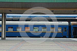 Blue passenger car with windows stands at the railway station