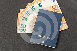 Blue passport with blank covers and cash euros on black background. Budget travel. State payments concept