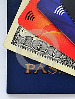 Blue passport, one hundred dollars bill and three different credit cards