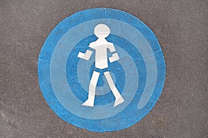 Blue pedestrian sign on road